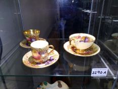 Three Aynsley Orchard gold tea cups and saucers. The large cup has a repair to the handle.