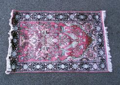 A pink floral rug with black border. COLLECT ONLY.