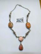 A pink stone set necklace in a silver coloured metal