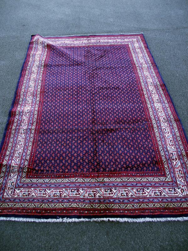 A blue and red patterned rug. Length 332 cm x 216cm. COLLECT ONLY.