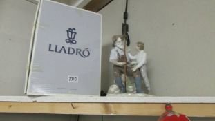 A boxed Lladro Fishing Lesson withdrawn 1/1/2003 Width 18cm x 15cm x height 30cm.