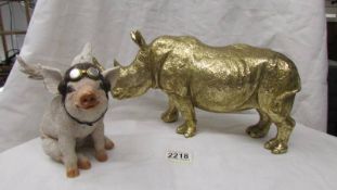 A gold coloured Rhinocerous and a flying pig.