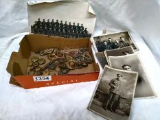 A collection of military photographs, plus military badges and buttons