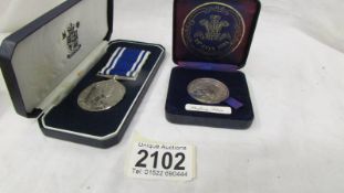 A cased Exemplary police service medal and a silver Charles & Diana coin.