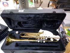 A cased brass style trumpet with mouthpiece.