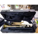 A cased brass style trumpet with mouthpiece.