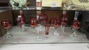 A quantity of red glass wine and brandy glasses.