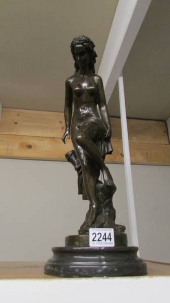 A bronze nude figure on a plinth.