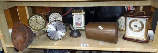 A shelf on mantel clocks and copper ware.