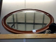 An oval framed bevelled edge wall mirror. COLLECT ONLY.