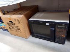 A boxed Toshiba ER692ET microwave oven