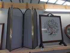 An oak fire screen with embroidered panel and a 4 fold brass screen.
