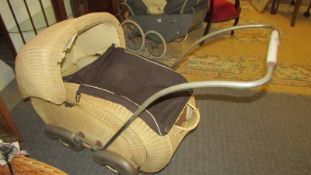 An early 20th century cane babies pram. COLLECT ONLY.