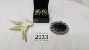 A pair of amber earrings in silver, an oval silver brooch with onyx centre & a vintage bird brooch.