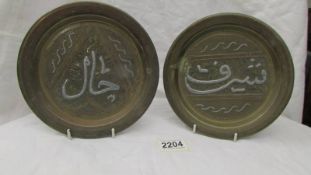 A pair of silver overlaid Cairo ware Mamaluk brass wall plaques. 19cm diameter.