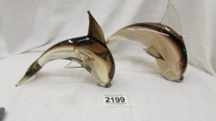 Two smoked glass dolphins.