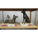 Two bronze dogs on a marble base.