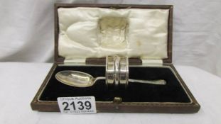 A cased silver spoon and napkin ring.