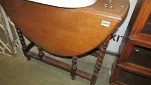 An oak gate leg table with barley twist legs. COLLECT ONLY.