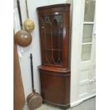 A dark wood stained and glazed corner cabinet