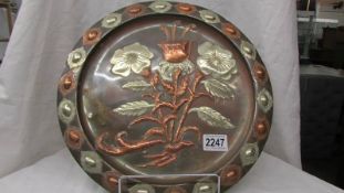 A large brass Cairo ware art nouveau style plaque with relief copper & silvered flowers, 34.5 cm