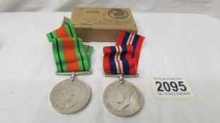 A 1939-45 defence medal and one other with original box.