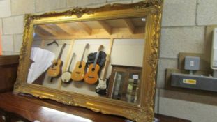 A large ornate gilt framed mirror, 148cm wide x 86 cm high. COLLECT ONLY.