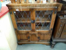A 1950's oak display cabinet with leaded doors, 84 x 26 x 103 cm high, COLLECT ONLY.