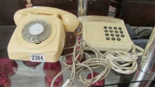 Two vintage cream coloured telephones.