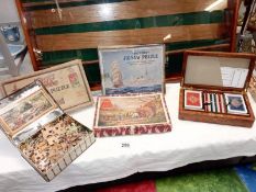 A good lot of vintage jigsaws and a playing card box.