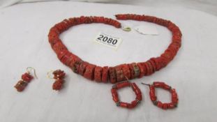 A coral necklace and two pairs of earrings.