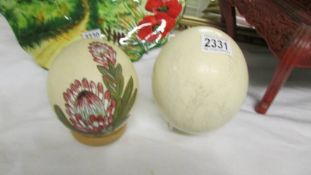 Two hand decorated ostrich eggs.