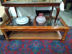 A mahogany coffee table with bevel glass top and bergere panel shelf. 133 cm x 57cm x height 42cm,