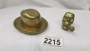 A brass stetson matchstriker marked Battersby hats and a skull matchstriker (go to bed light).