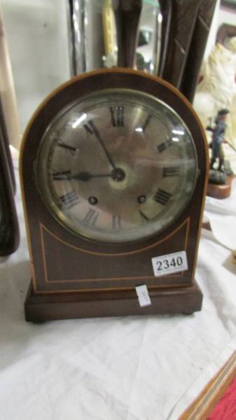 A mahogany inlaid mantel clock, W & H SCH, with pendulum and key, in working order.