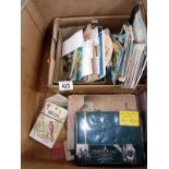 A box of postcards, an album of postcards and some assorted small books