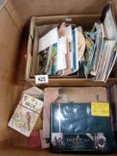 A box of postcards, an album of postcards and some assorted small books