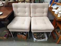 A pair of button upholstered retro chairs with casters and chromed frame.