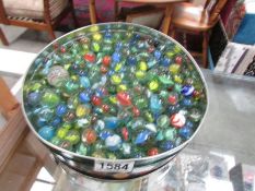 A tin of coloured glass marbles.