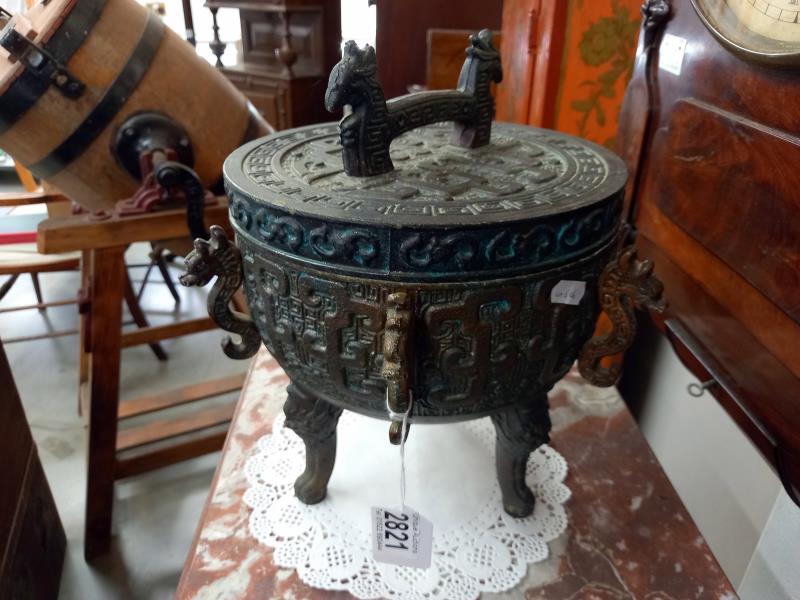 A Chinese lidded cauldron on three feet.