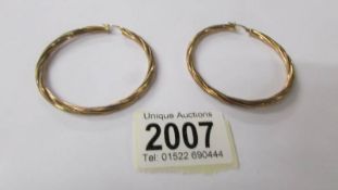 A large pair of 9ct gold hoop earrings, 4 grams.