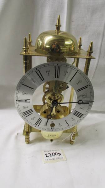 A modern brass 'Skeleton' style clock.