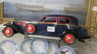 A large tin plate clockwork pre war style car by Peyo with opening doors and boot, Length 50 cm.