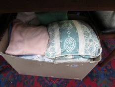 A box of blankets, cushions, cardigans etc.,