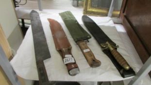 Four old hunting knives, three in sheaths.