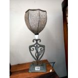 A vintage wrought iron table lamp with glass shade