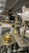 Two brass inkwells and a quantity of brass candlesticks.