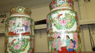 A pair of Cantonese Famille Rose lidded jars, 25cm high x 14.5cm diameter.