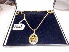 An ornate 9ct gold pendant and chain set turquoise and possibly yellow sapphire. 37 grams.