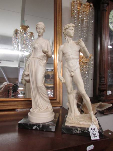 A pair of Grecian style figures on marble bases.
